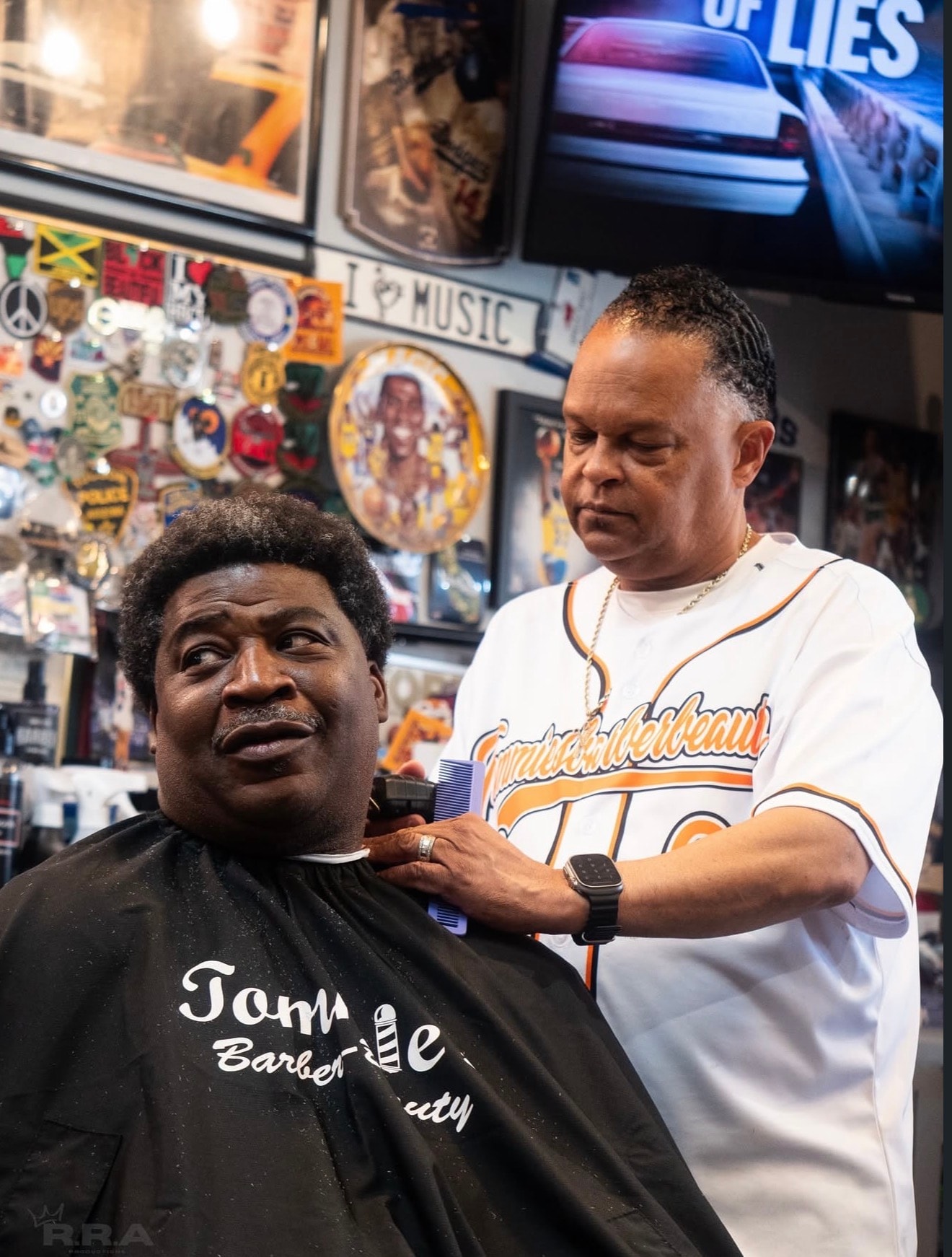 Barber giving a haircut to a client in Tommie's Barber-Beauty shop