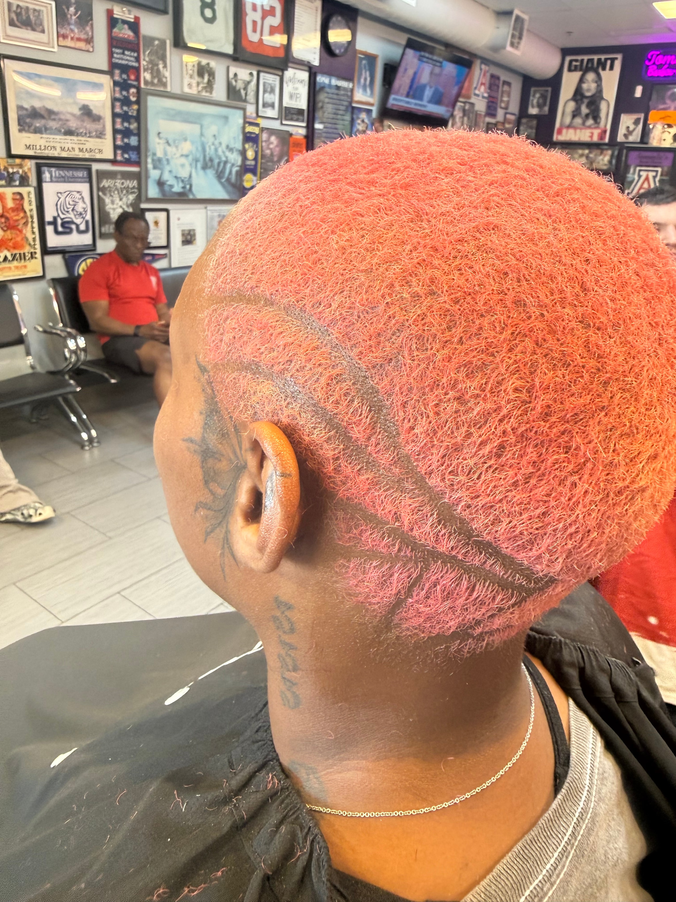 Creative red colored hair design with razor lines at Tommie's