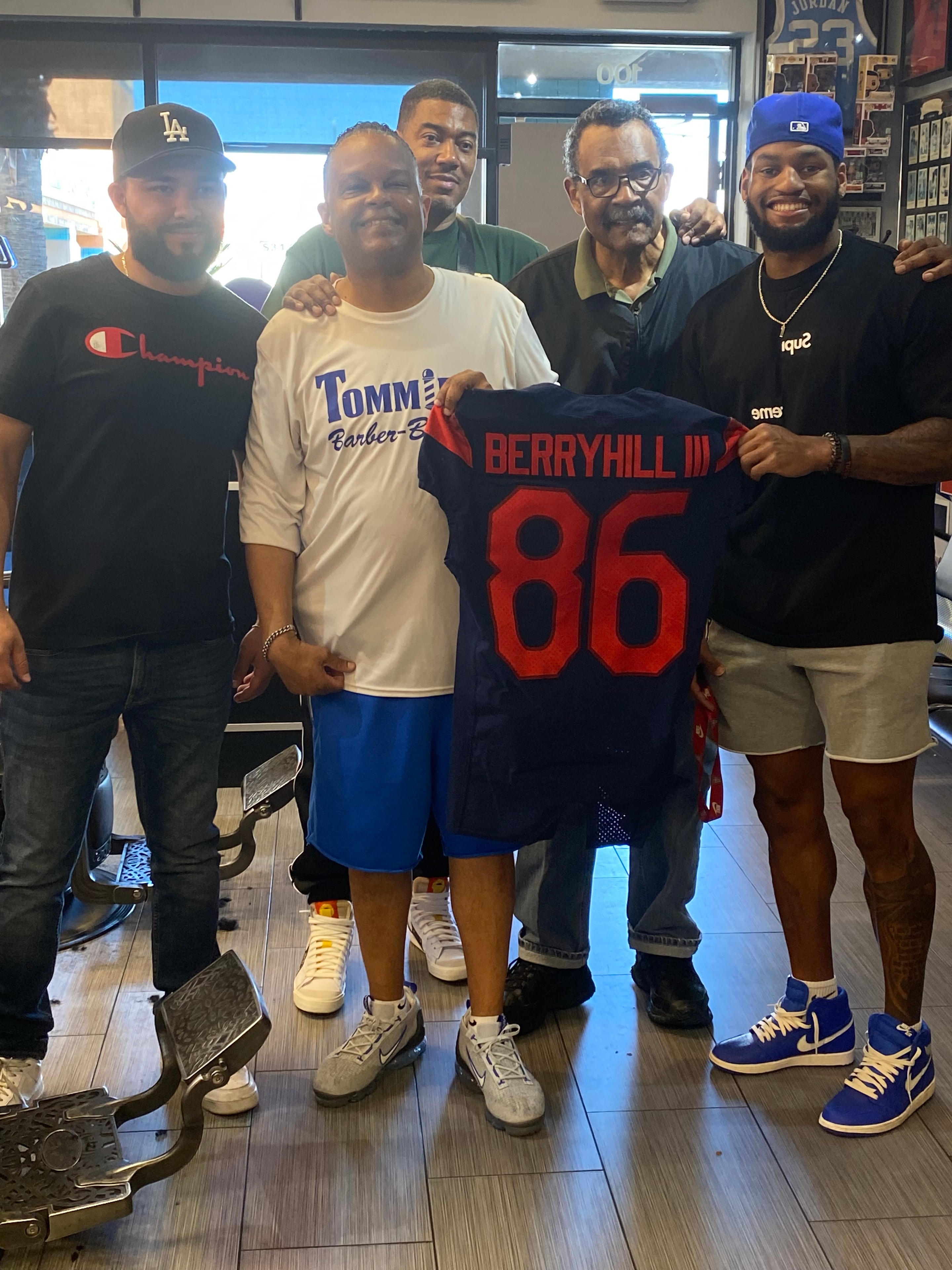 Group photo with Berryhill jersey at Tommie's Barber-Beauty